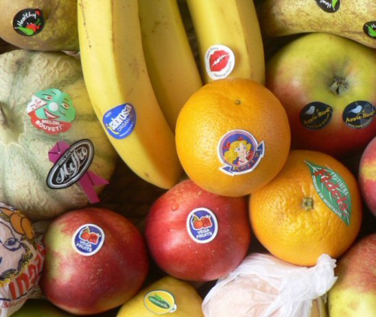 Fruits variés ornés d'étiquettes de marques colorées.